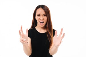 Close-up of young annoyed angry asian woman holding hands in furious gesture, looking at camera