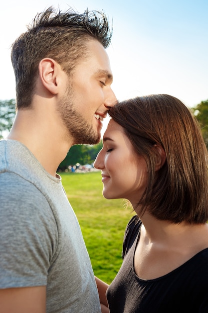 Close up young beautiful couple kissing in park.