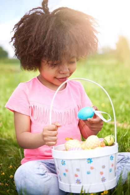 Close up on young beautiful girl looking at colorful Easter eggs