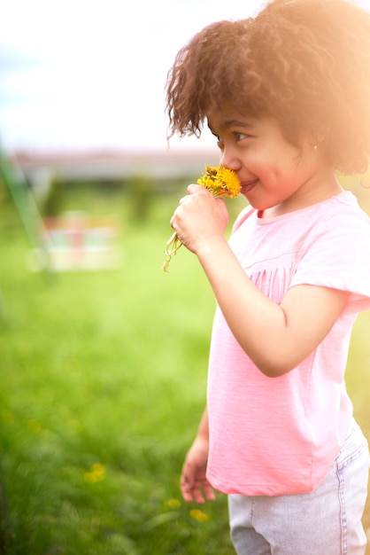 Close up on young beautiful girl smelling flowers