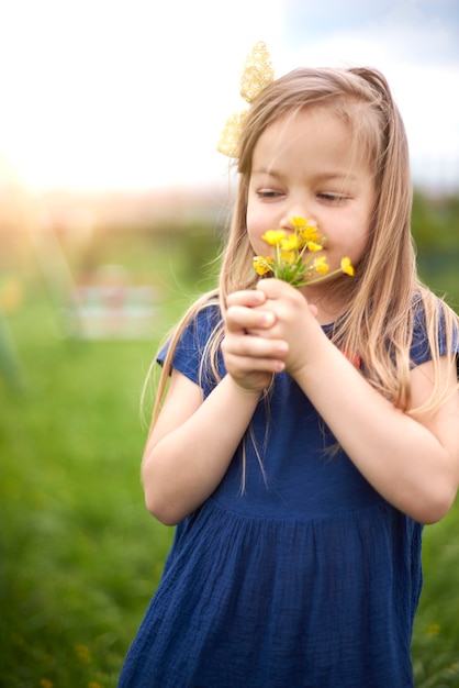 Close up on young beautiful girl smelling flowers