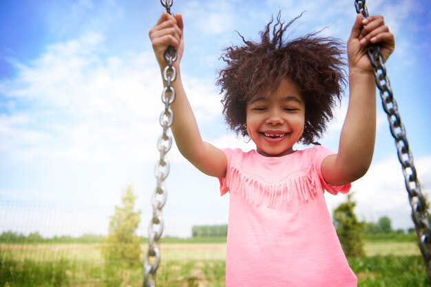 Close up on young beautiful girl swinging