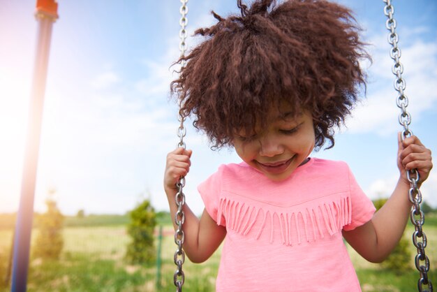 Close up on young beautiful girl swinging
