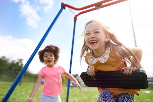 Free photo close up on young beautiful girls playing with swing