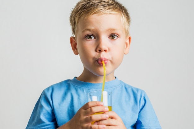 Free photo close-up young boy drinking juice