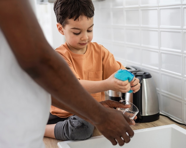 Close up on young boy helping with dishes