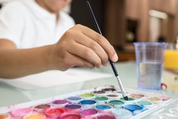 Close-up young boy painting at home