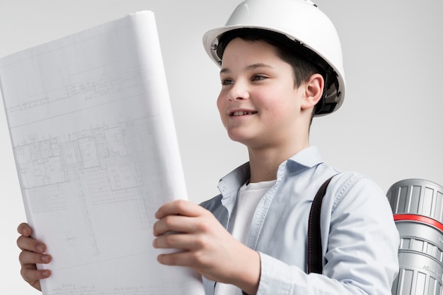 Free photo close-up young boy reading construction plan