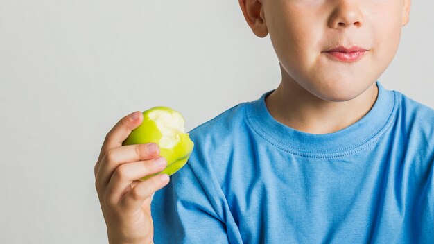 Close-up young boy with a green apple