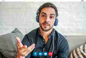 Free photo close-up of a young businessman having a work video call while staying at home. new normal lifestyle. business concept.