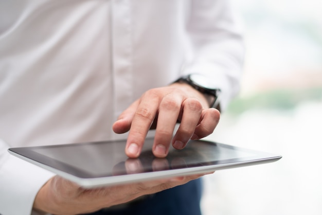 Close-up of young businessman using digital tablet