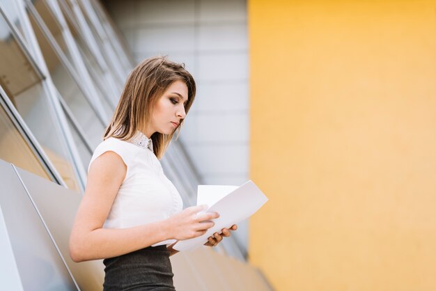 Close-up of a young businesswoman checking the paper documents