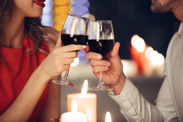 ワインとグラスを保持している若いカップルのクローズアップ