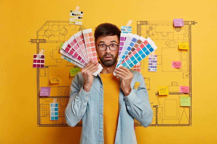 मुफ़्त फोटो close up on young designer getting ready to renovate next to house master plan sketch