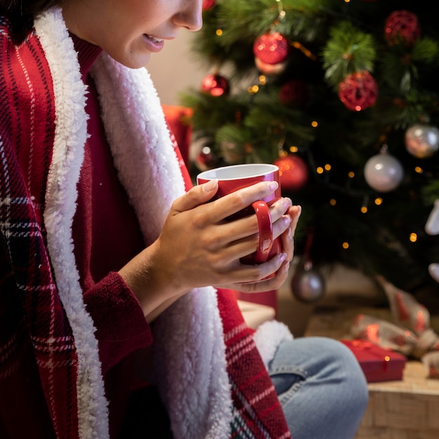 Giovane femmina del primo piano con la tazza di tè