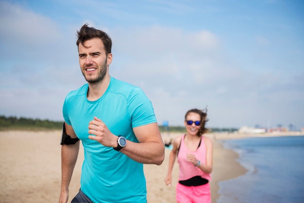 Close up on young fit people jogging by the sea