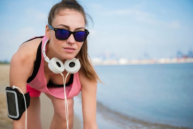 Foto gratuita primo piano su giovane persona in forma fare jogging in riva al mare