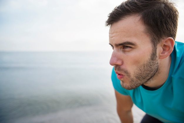 Close up on young fit person jogging by the sea