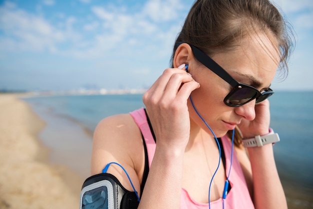 Close up on young fit person jogging by the sea