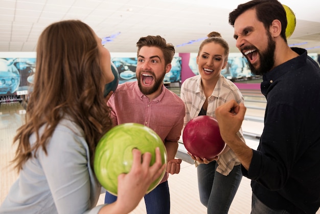 Close up on young friends enjoying bowling