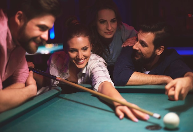 Close up on young friends having fun while playing pool game