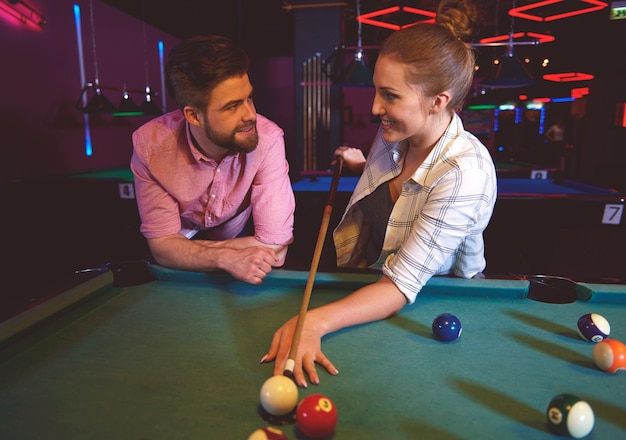 Close up on young friends having fun while playing pool game