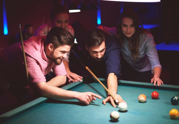 Free photo close up on young friends having fun while playing pool game