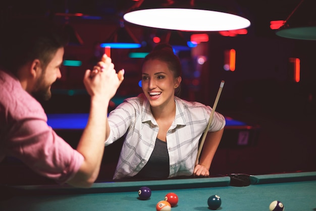 Free photo close up on young friends having fun while playing pool game