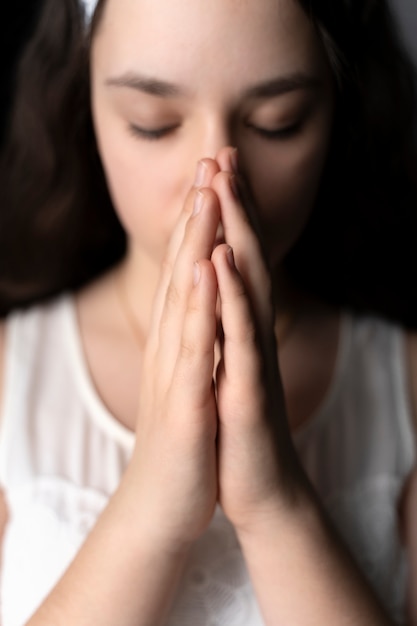 Крупным планом молодая девушка молится