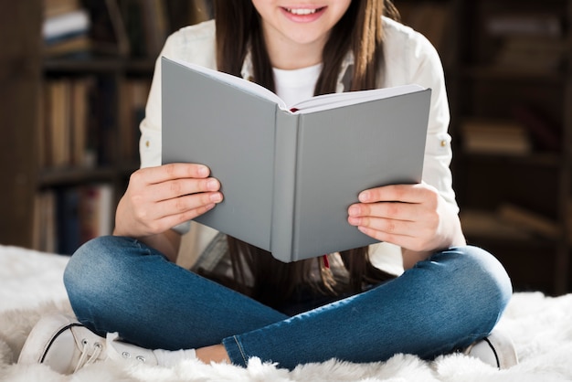 Ragazza del primo piano che legge un libro