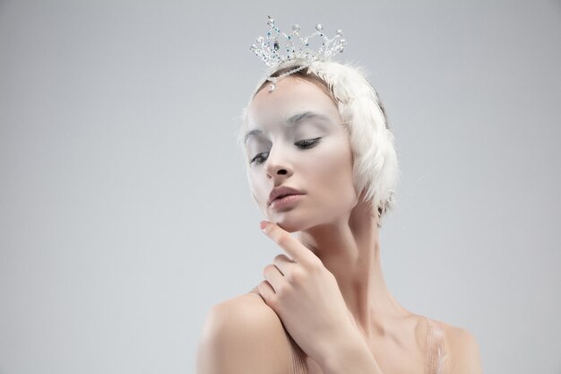 Close up of young graceful ballerina on white studio background