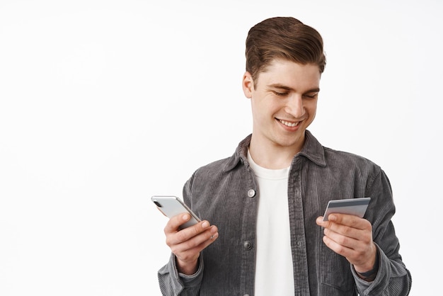 Free Photo | Close up of young guy paying with mobile phone app and credit  card shopping online insert bank number to make purchase order in internet white  background