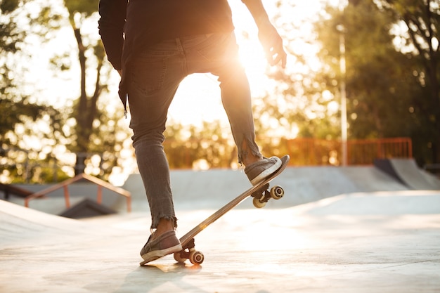 Заделывают молодой мужской скейтбордист обучение в скейт-парк
