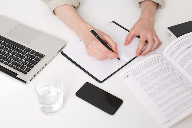 Free photo close up of young man hands writing notes