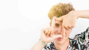 Free photo close-up of a young man looking through finger frame