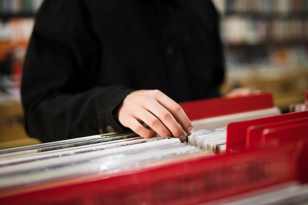 Close-up young man looking for vinyls in store