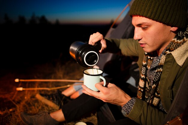 Close-up young man pouring a hot drink