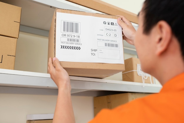 Close up on young man taking box from shelf