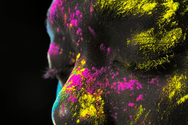 Close up young model with colorful powder