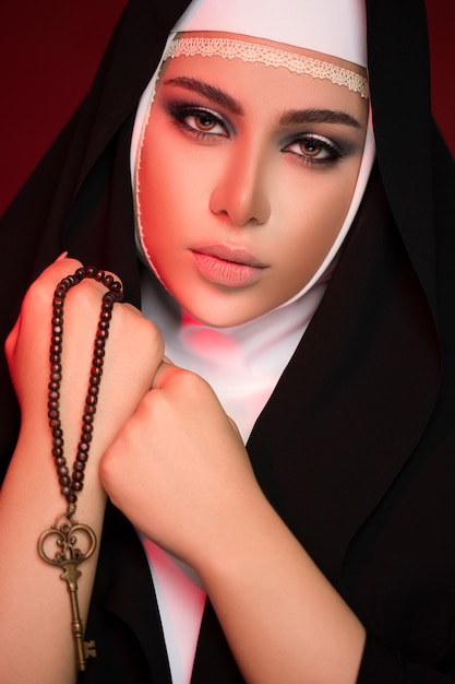 彼の手でキーを保持したヒジャーブの黒い服を着た若いイスラム教徒の女性を閉じる