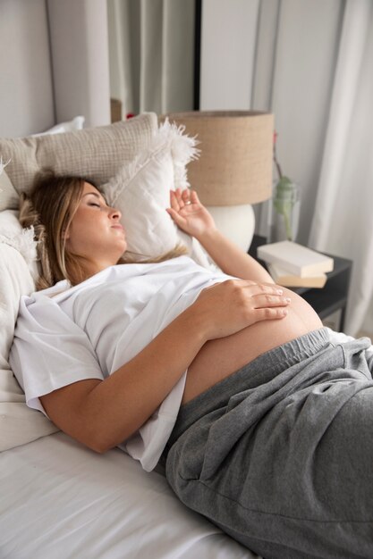 Крупным планом на спящей молодой беременной женщине