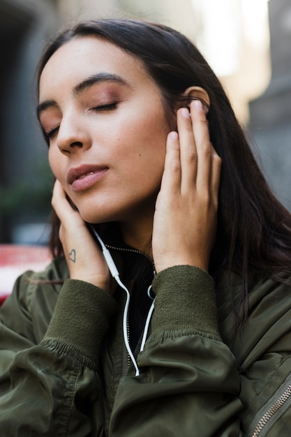 Foto gratuita primo piano di una giovane donna che gode della musica sul trasduttore auricolare