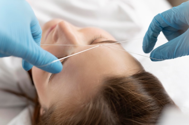 Close-up of young woman getting an eyebrow treatment