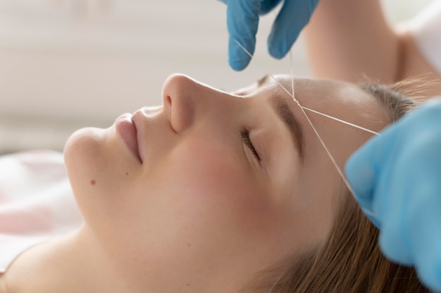 Close-up of young woman getting an eyebrow treatment