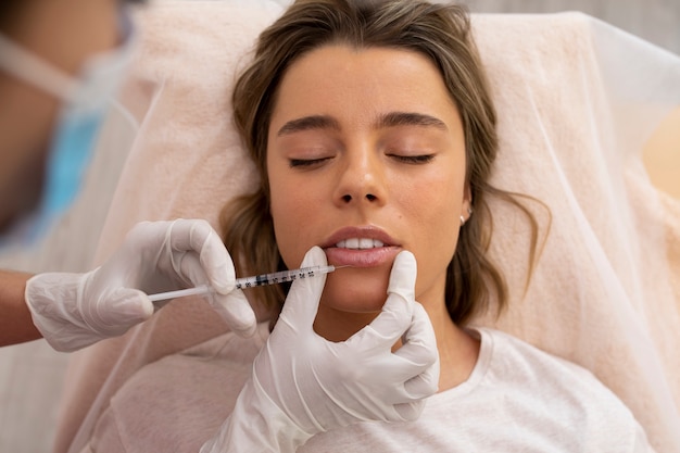 Close up young woman getting lip filler