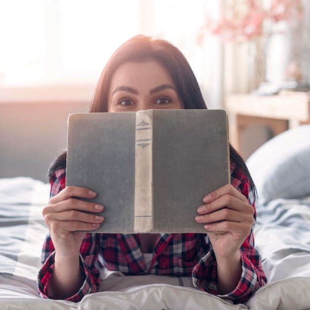 Foto gratuita giovane donna del primo piano che tiene un libro