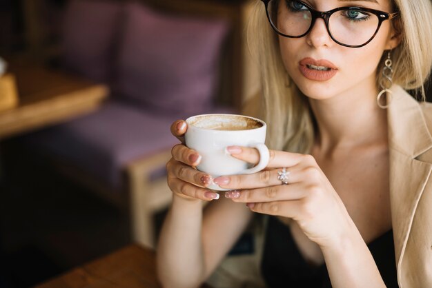 Close-up of young woman holding coffee cup