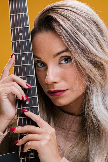 Крупный план молодой женщины, держащей гитару