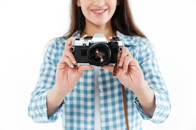 Close up of young woman holding retro camera isolated