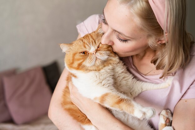 Крупным планом молодая женщина, целуя кошку